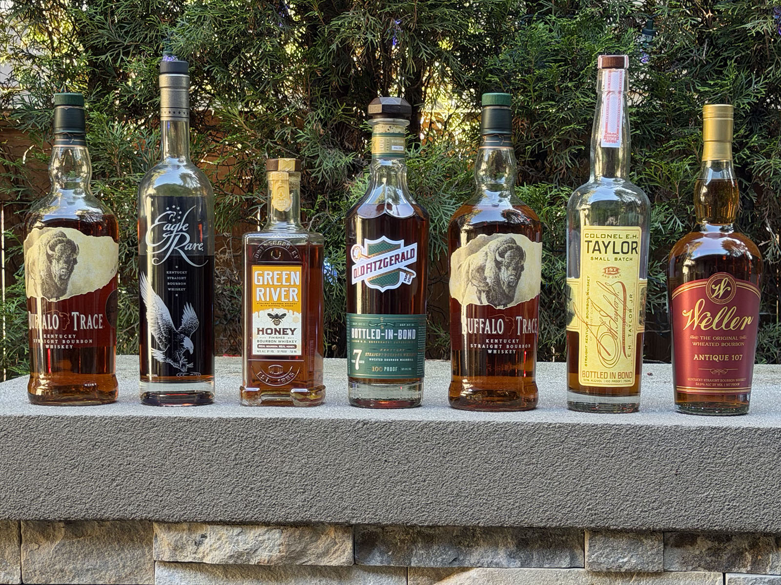 Bourbon bottles lined up outdoors for a tasting