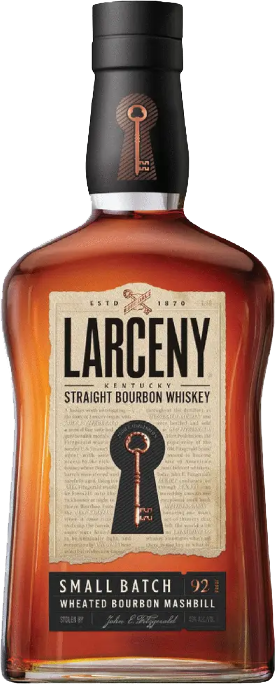 A glass of honey-amber bourbon in gentle candlelight
